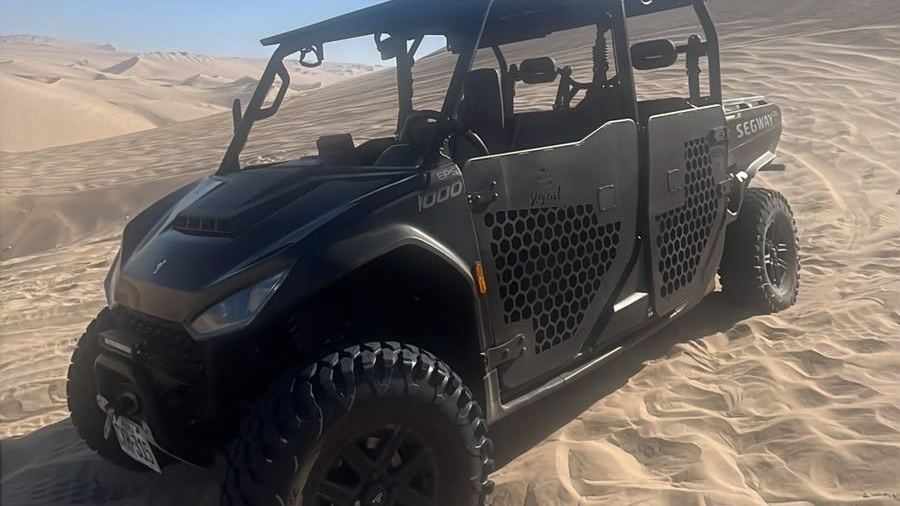 UTV negro de fábrica, con jaula antivuelco, detenido en una duna de Huacachina